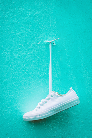 White sneakers hung up against the blue walls.