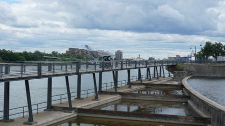 Montreal, QC/ Canada - 6/25/2020: A family rides a quadricycle over a bridge at the old port after the ease of the lockdown of coronavirus. Background is Habitat 67.のeditorial素材