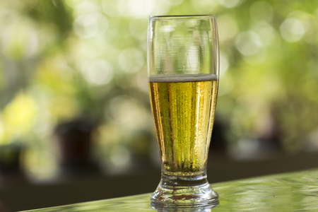 Glass of cold beer on the table and unfocused backgroundの写真素材