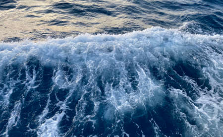 Seawater surface. White foam waves texture as a natural background.