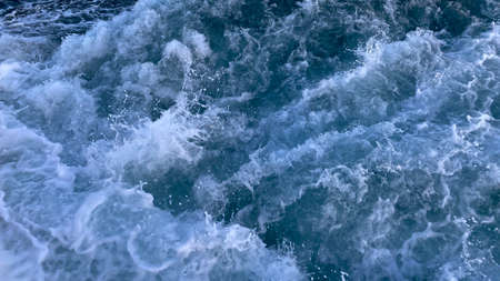 Seawater surface. White foam waves texture as a natural background.