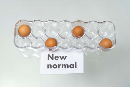 NEW NORMAL word with eggs in a carton. New normal concept. Social distancing. Selective focus.