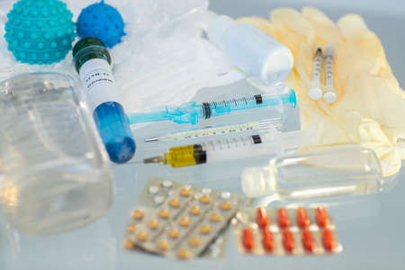 Vaccine for coronavirus. Concept of discovering a vaccine for coronavirus. Needle syringe, facemask, bottle medicine, tablets pills, thermometer, Together we protect ourself from COVID-19.の写真素材