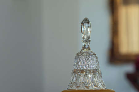 Crystal bell. Blurred background. Glass object.