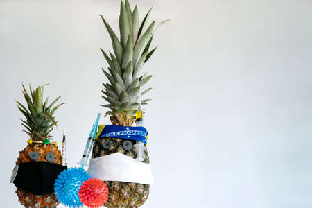 Wearing mask and vaccine. Pandemic, a portrait of a Pineapple wearing a protective mask.の写真素材