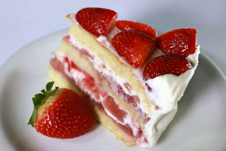 Homemade strawberry cake cut. Strawberry pie decorated with fresh strawberries stands on a plate. Cut off a piece.の写真素材