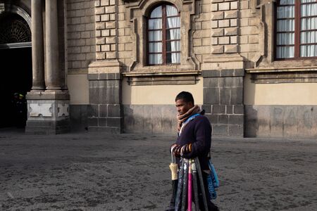 Sicily, Italy - January 12, 2016: Unknown immigrant selling umbrellas near Piazza Duomo in Catania city centre.のeditorial素材
