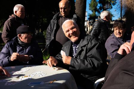 Sicily, Italy - January 21, 2016: Unknown old men playing cards at the local park this morning in...