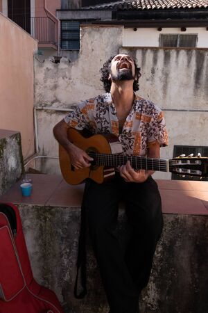 Sicily, Italy - February 05, 2016: Unknown man stands playing guitar in the balcony at Catania.