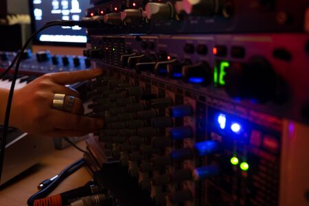 Sicily, Italy - February 29, 2016: Person adjusting the levels in an audio equipment in the recording studio at Catania.のeditorial素材