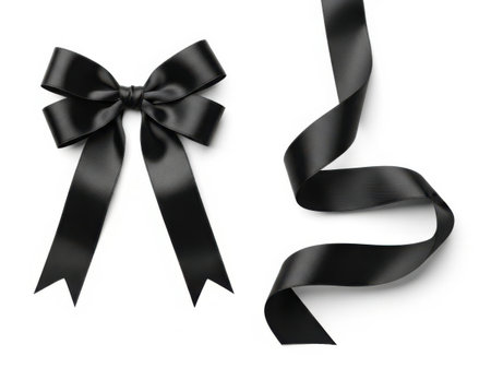 A sophisticated black ribbon bow with long, flowing ends, set against a pristine white background.の素材
