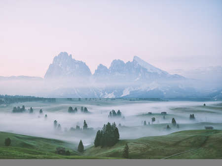 Foggy morning in the Dolomites. The peaks of the mountains are shrouded in fog.