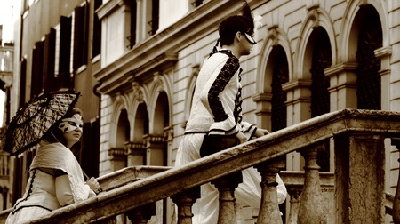 Sepia Venice Carnival couple climbing stairs on bridge