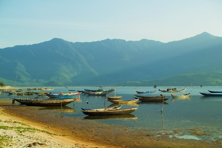 Old, wooden boats tied at dry shoreの写真素材