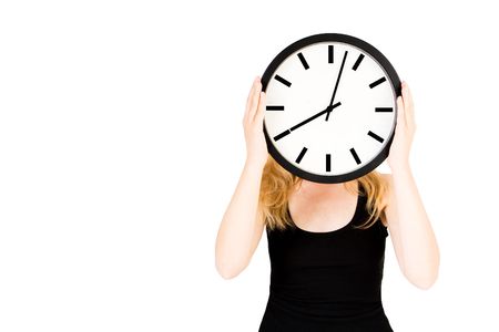 A blond woman holding a clock infront of her faceの写真素材