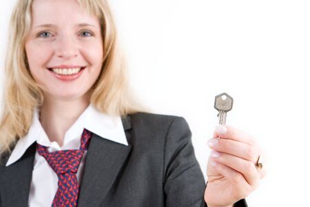 A business woman holding a silver key out in front of herの写真素材