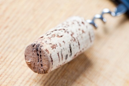 Cork with wine opener on a wooden backgroundの写真素材