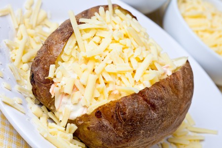 Hot and crispy baked potato stuffed with cheddar cheese and coleslawの写真素材