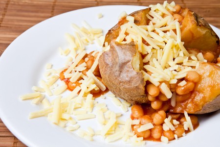 Hot and crispy baked potato stuffed with baked beans and cheddar cheeseの写真素材