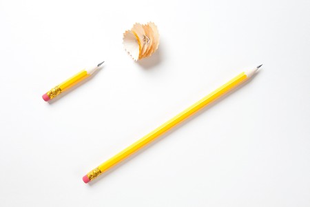 Long and a short pencil on textured white paper with shavingsの写真素材