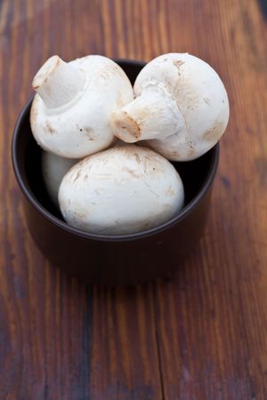 Button mushrooms in a brown cupの写真素材