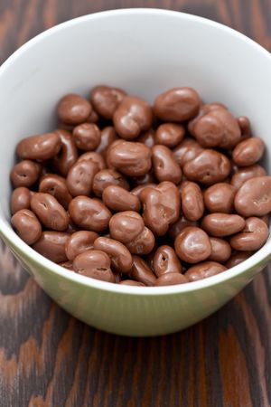 Raisins covered in delicious chocolate  in a green bowlの写真素材