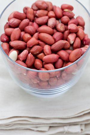 Shelled red peanuts in a glass on a napkin