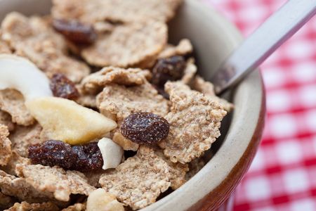 Healthy breakfast of bran flakes with raisins in a pot bowl