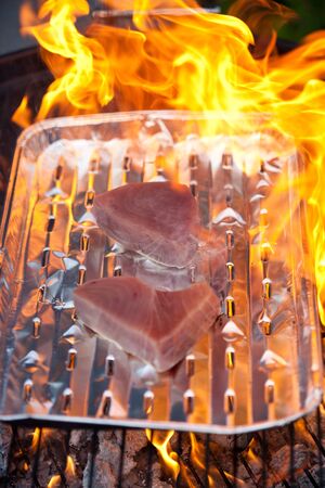 Two tuna steaks on a silver tray on a BBQの写真素材