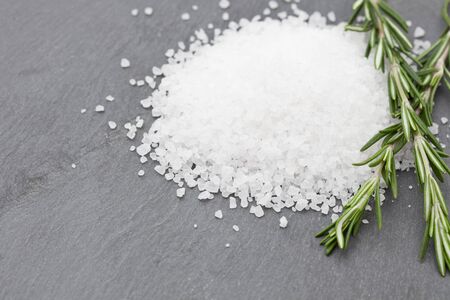 Sea salt with rosemary on a slateの写真素材