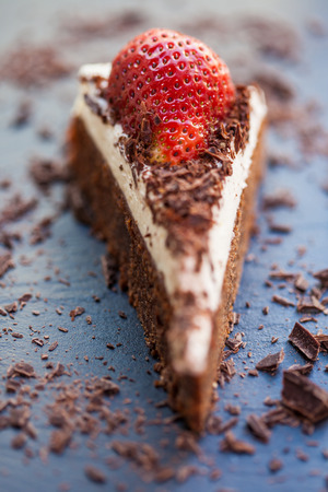 Slice of delicious chocolate and mascarpone cake with a fresh strawberriey and roughly chopped chocolate flakes  Shallow DOF の写真素材