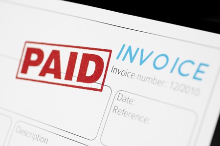 Close-up picture of an invoice with red paid stamp.