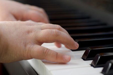 Closeup image of a child playing the pianoの写真素材