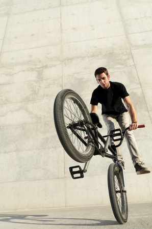 Young bicycle rider on a grey urban concrete background Young bicycle rider on a grey urban concrete background