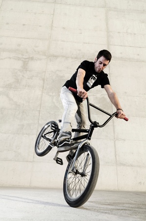 Young bicycle rider on a grey urban concrete backgroundの写真素材