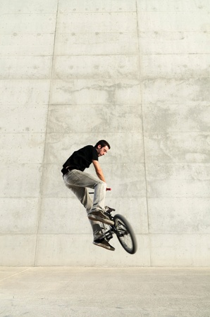 Young bicycle rider on a grey urban concrete backgroundの写真素材