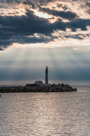 Lighthouse of Port-La-Nouvelle in red and white on cloudy sky in Occitanie, Franceの写真素材