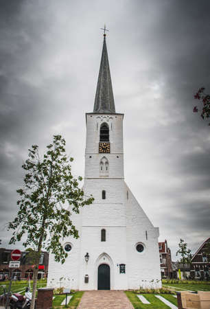 White church in Noordwijkerhout in the Netherlands with cloudy skyの写真素材