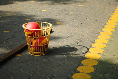 Ball in basket with shadow on the pavement, outdoor shotの写真素材