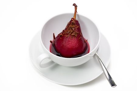 Pear with stem poached in red wine in cup with chocolate shavings.の写真素材