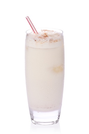 Glass of iced horchata with straw against white background.の写真素材