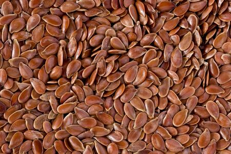 Background texture of brown flax seeds.