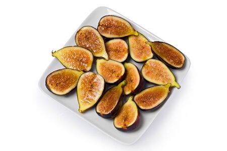 Several black mission fig slices on a square white plate.の写真素材