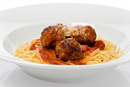 Spaghetti and meatballs in a white bowl against a white background.の写真素材