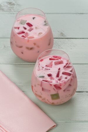 Two Buko Salad drinks in glasses on a green painted wood background.の写真素材