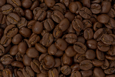 Background texture of whole medium-dark roasted coffee beans.の写真素材