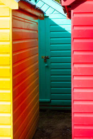 A close-up of three brightly painted beach huts, removed from the beach for winter storageの写真素材