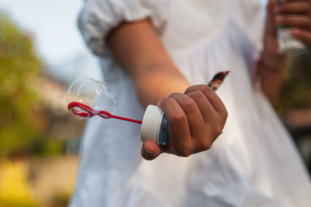 DETAIL PHOTO OF A SOAP BUBBLE IN A GIRL'S HAND