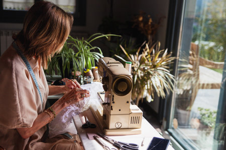 Woman in her sewing room sewing a dress with the sewing machineの写真素材