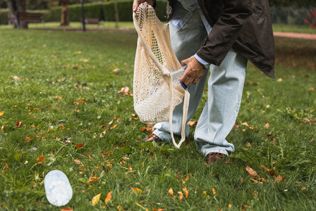 Young man at the recycling garbage can smiling for helping with the wasteの写真素材